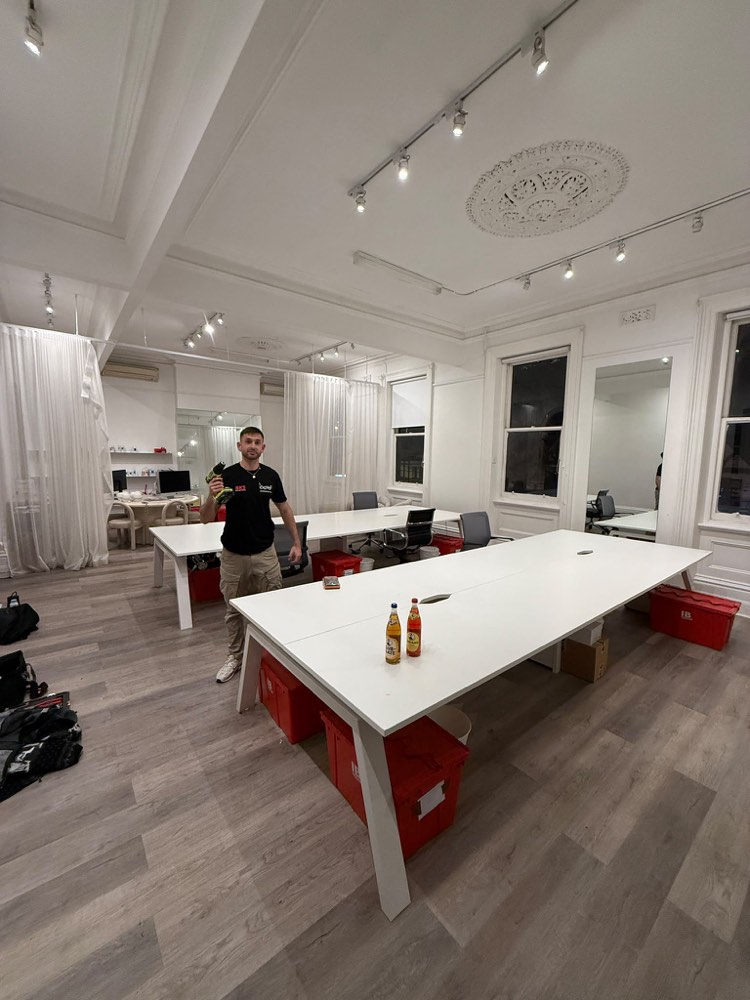 Ben with a drill after assembling the desks at Andre’s new office